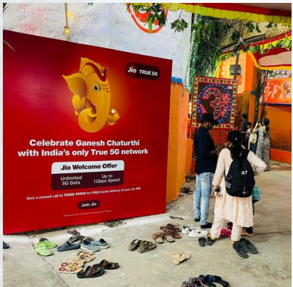 Festival activation with a red wall branding and people
