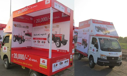 A fleet of vehicles with colorful custom wraps and decals driving on a city street during a mobile brand activation event